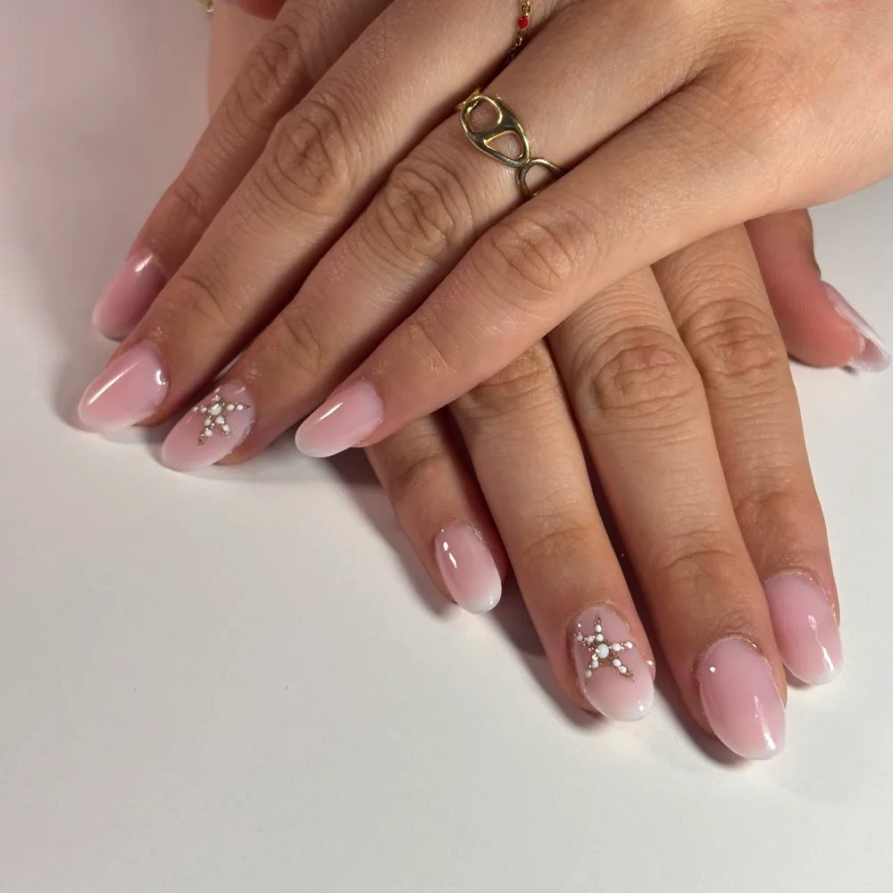 Pose gel amande en dégradé baby boomer rose et blanc, motif de strass sur un ongle de chaque main