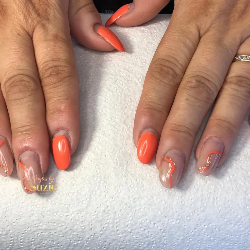 Ongles amande corail vif, deux ongles transparents par main traversés d'une vague corail et or pailleté